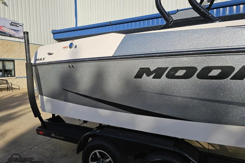 Slide: The Image of 2020 Moomba Max boat with sleek design, parked on a trailer outside a building. - 7