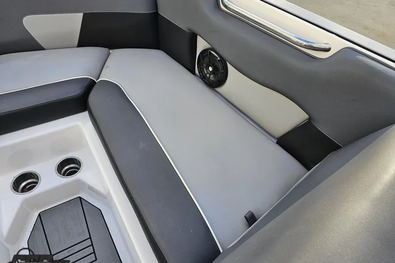 Slide: The Image of 2020 Moomba Max boat interior with gray seating, cup holders, and speaker. - 74