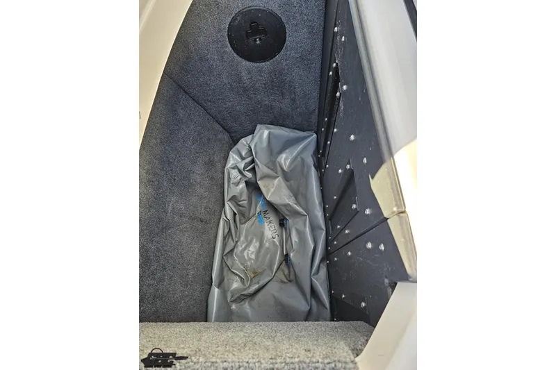 Slide: The Image of 2020 Moomba Max boat storage compartment with gray interior and ballast bag. - 93