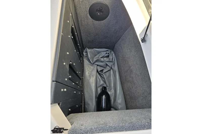 Slide: The Image of 2020 Moomba Max storage compartment with black bottle and gray lining. - 95