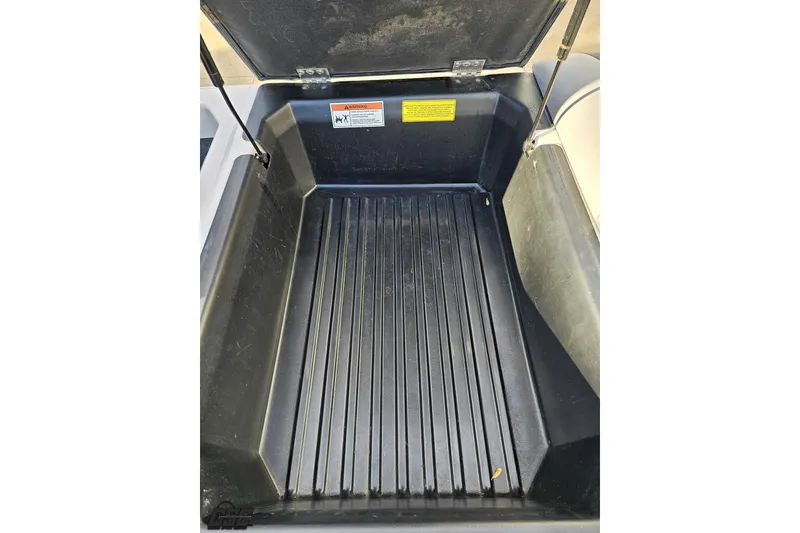 Slide: The Image of Open storage compartment in 2020 Moomba Max boat, featuring a ribbed black interior. - 97