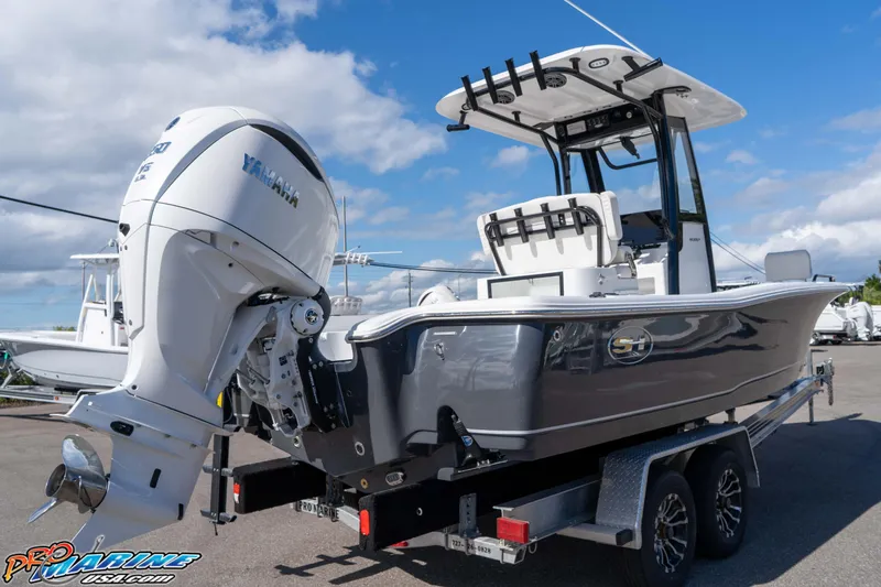 Slide: The Image of 2026 Sea Hunt BX 25 FS boat with Yamaha engine on trailer, under clear blue sky. - 15