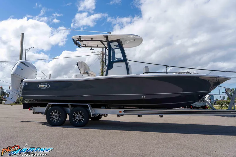 Slide: The Image of 2026 Sea Hunt BX 25 FS boat on trailer under a cloudy sky. - 17