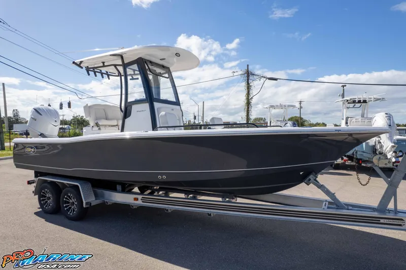 Slide: The Image of 2026 Sea Hunt BX 25 FS boat on trailer, parked outdoors under a clear sky. - 24
