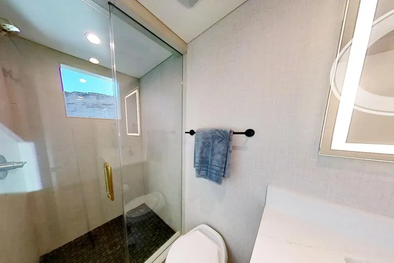 Slide: The Image of Modern bathroom in 2022 Adonia Splendor RV with glass shower and towel rack. - 14