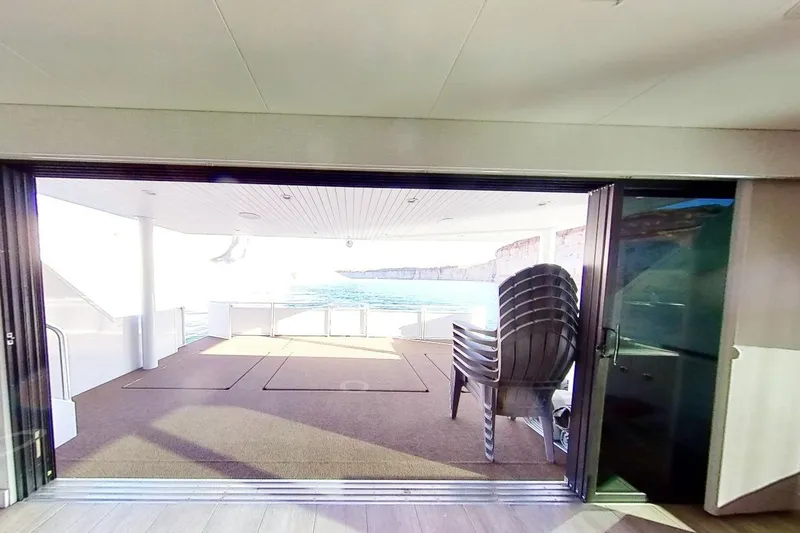 Slide: The Image of Luxury yacht Adonia Splendor 2022, spacious deck with ocean view and stacked chairs. - 21