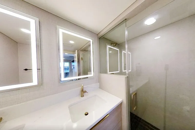 Slide: The Image of Modern bathroom with illuminated mirrors, glass shower, and sleek fixtures in Adonia Splendor 2022 model. - 31