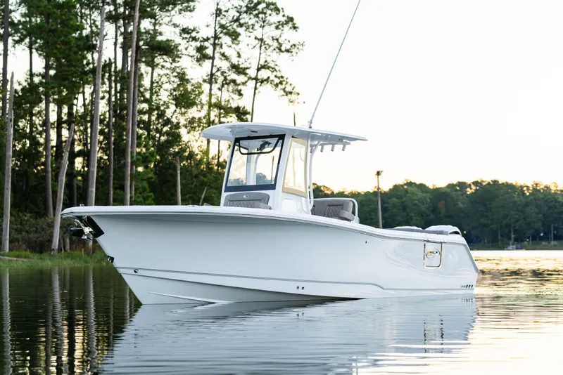 Slide: The Image of 2026 Sea Hunt Ultra 275 Coffin Box boat on calm water, surrounded by trees. - 18