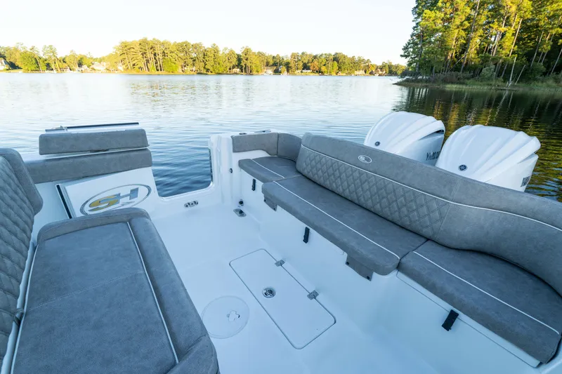Slide: The Image of 2026 Sea Hunt Ultra 275 Coffin Box boat interior with gray seating on a serene lake. - 22