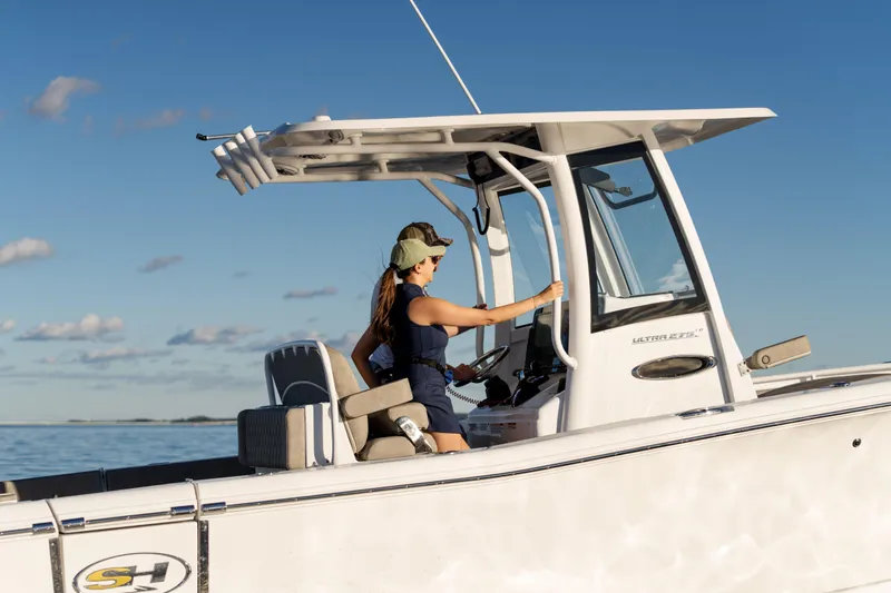 Slide: The Image of 2026 Sea Hunt Ultra 275 Coffin Box boat on calm water, two people navigating. - 9