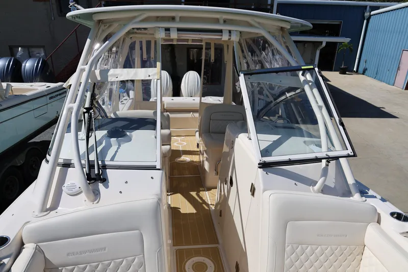 Slide: The Image of 2025 Grady-White Freedom 275 boat interior with seating and helm, docked outdoors. - 6