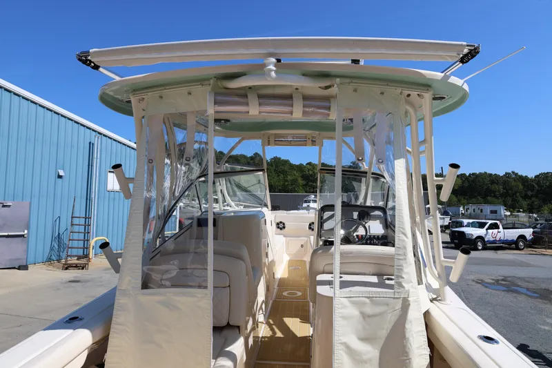 Slide: The Image of 2025 Grady-White Freedom 275 boat interior with canopy, docked outdoors. - 9