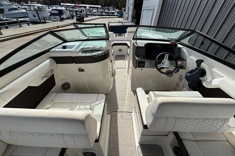 Slide: The Image of 2018 Sea Ray SDX 270 Outboard boat interior with white seating and modern dashboard. - 15