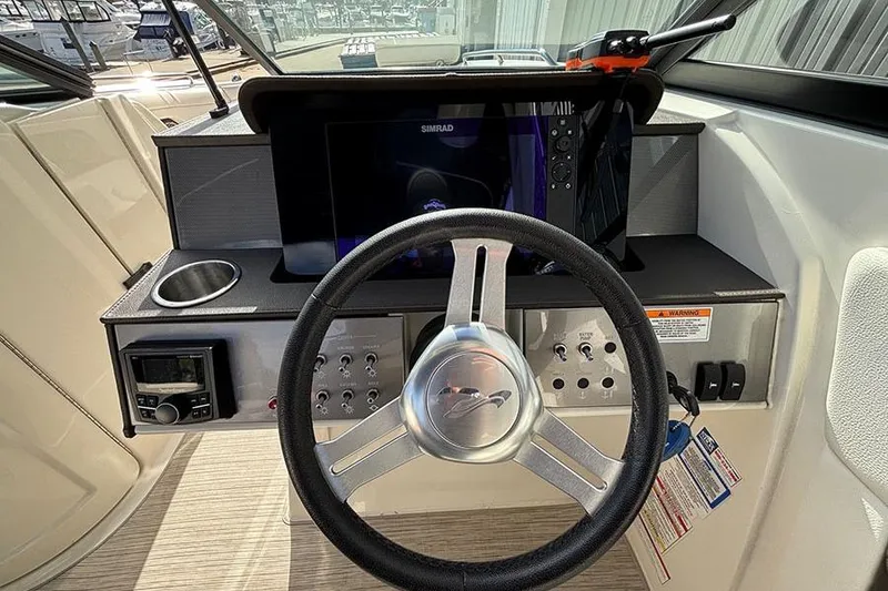 Slide: The Image of 2018 Sea Ray SDX 270 Outboard dashboard with steering wheel and navigation system. - 18