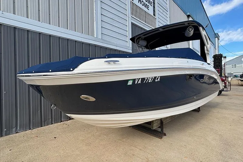 Slide: The Image of 2018 Sea Ray SDX 270 Outboard boat with blue cover, docked near a building. - 6