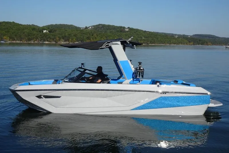 Slide: The Image of 2024 Nautique Super Air Nautique G23 boat on calm lake waters. - 11