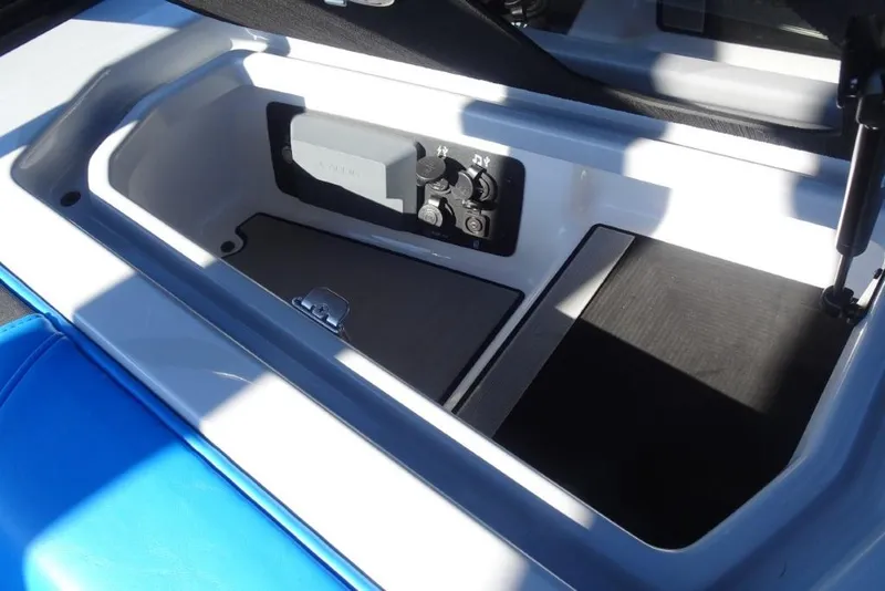 Slide: The Image of 2024 Nautique Super Air Nautique G23 storage compartment with control panel and blue seating. - 28