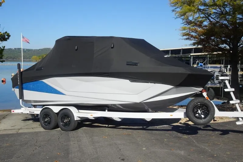 Slide: The Image of 2024 Nautique Super Air Nautique G23 boat covered on trailer by a lake. - 39