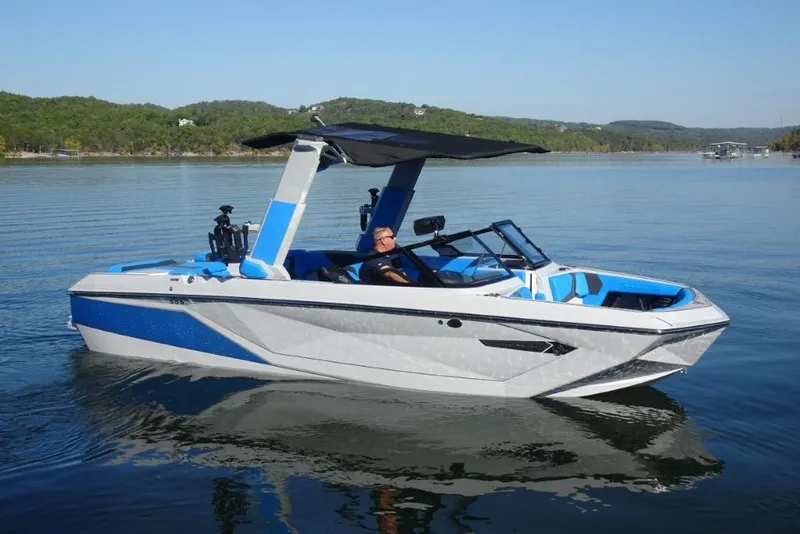Slide: The Image of 2024 Nautique Super Air Nautique G23 boat on a calm lake, featuring sleek design and blue accents. - 7