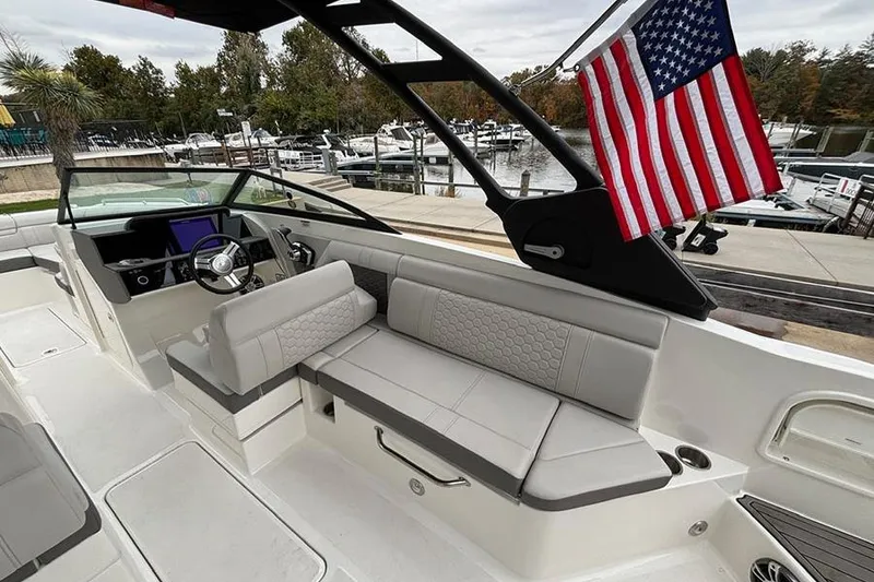 Slide: The Image of 2023 Sea Ray SDX 270 Outboard boat interior with American flag, docked at marina. - 10