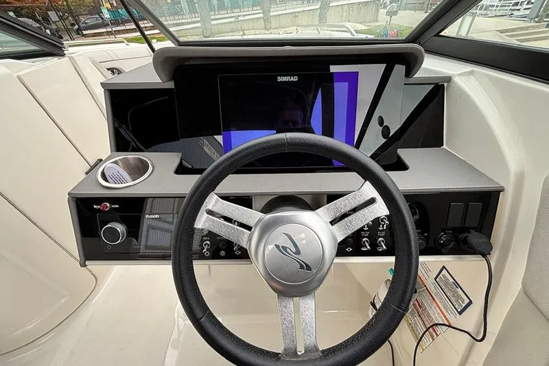 Slide: The Image of 2023 Sea Ray SDX 270 Outboard helm with steering wheel and Simrad display. - 15