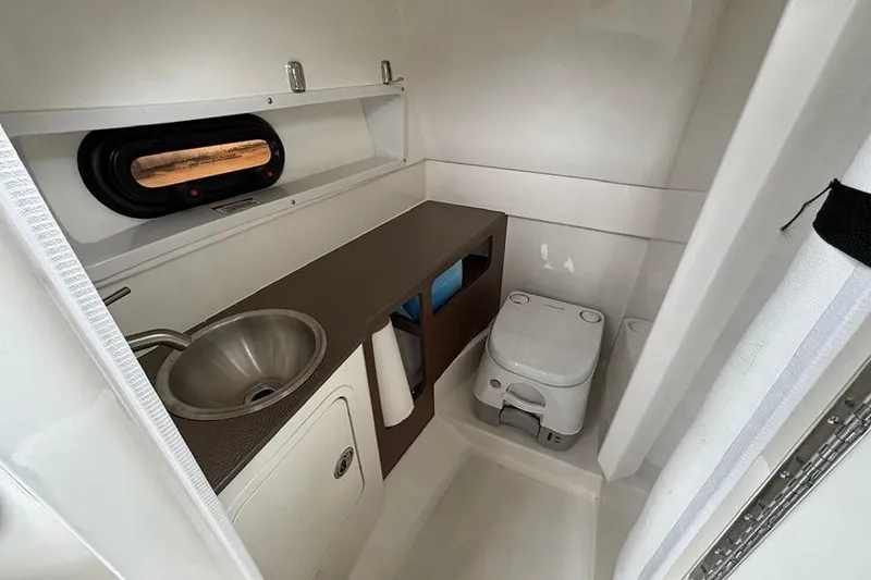 Slide: The Image of 2023 Sea Ray SDX 270 Outboard boat bathroom with sink and toilet. - 23