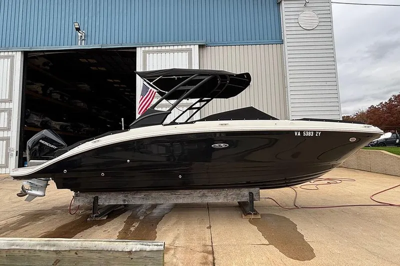 Slide: The Image of 2023 Sea Ray SDX 270 Outboard boat on a dock, black hull, American flag displayed. - 3