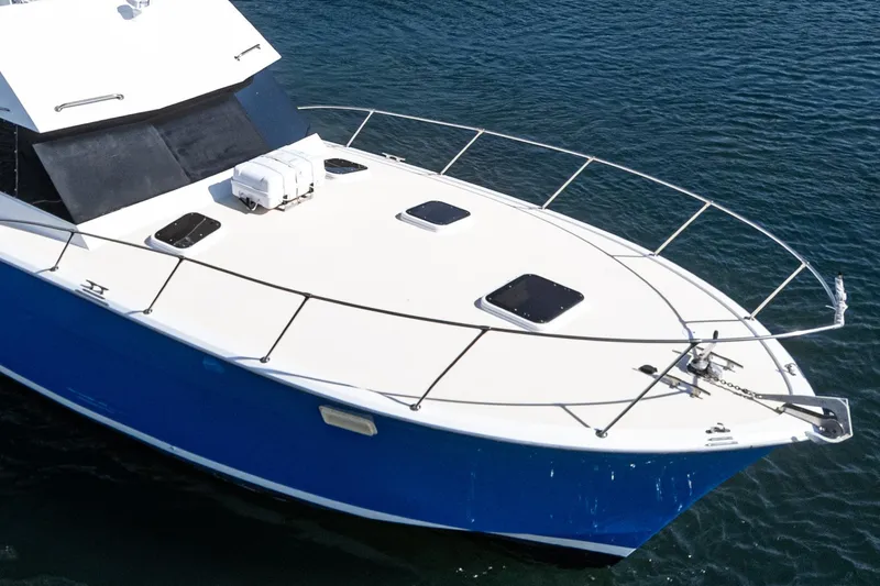 Slide: The Image of 1974 Hatteras Convertible Sportfisher boat with blue hull on calm water. - 10