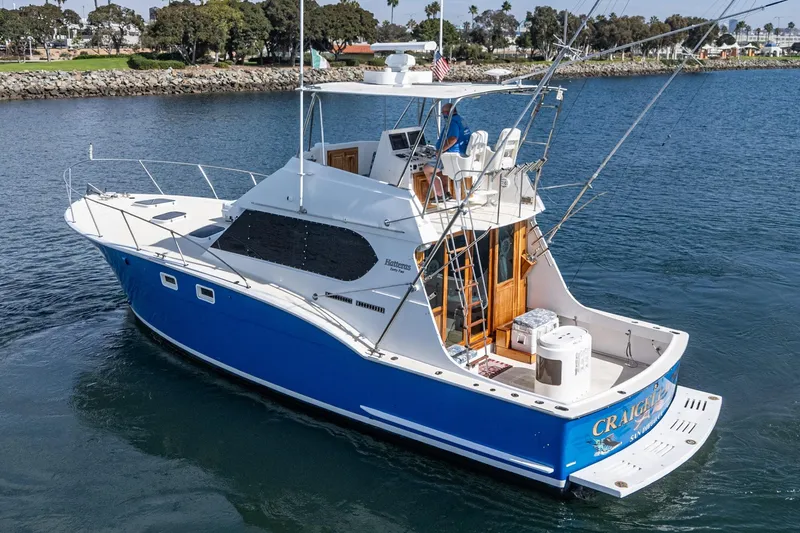 Slide: The Image of 1974 Hatteras Convertible Sportfisher boat with blue hull on calm water. - 12