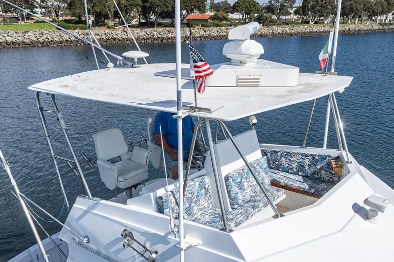 Slide: The Image of 1974 Hatteras Convertible Sportfisher boat with floral seating, docked in a serene marina. - 16