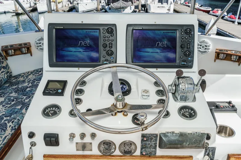 Slide: The Image of 1974 Hatteras Convertible Sportfisher helm with dual Furuno displays and classic controls. - 18