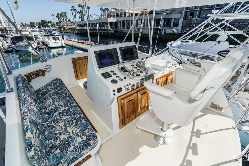 Slide: The Image of 1974 Hatteras Convertible Sportfisher helm with floral seating, marina view, and navigation equipment. - 20