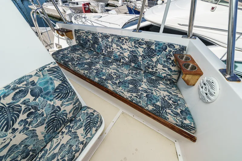 Slide: The Image of 1974 Hatteras Convertible Sportfisher boat seating with tropical-patterned cushions and cup holders. - 21