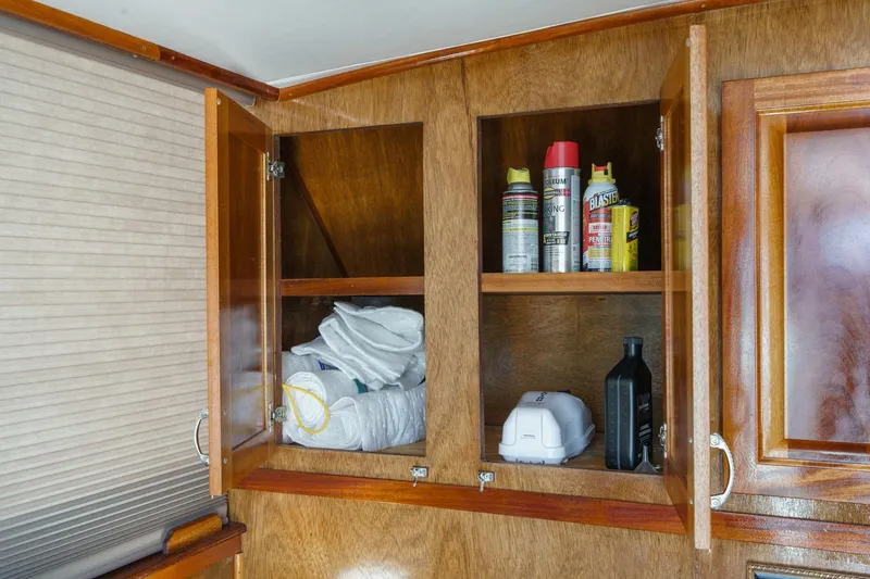 Slide: The Image of 1974 Hatteras Convertible Sportfisher wooden cabinet with cleaning supplies and linens. - 40