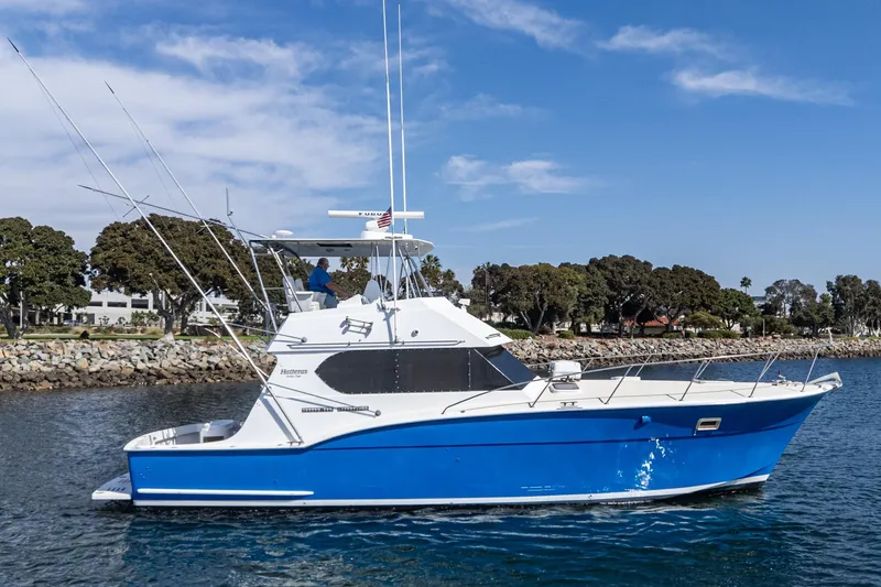Slide: The Image of 1974 Hatteras Convertible Sportfisher boat on water, blue hull, clear sky background. - 5