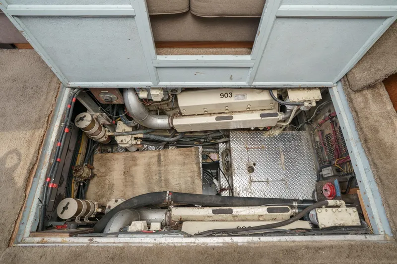 Slide: The Image of Engine room of a 1974 Hatteras Convertible Sportfisher, showcasing mechanical components and wiring. - 53
