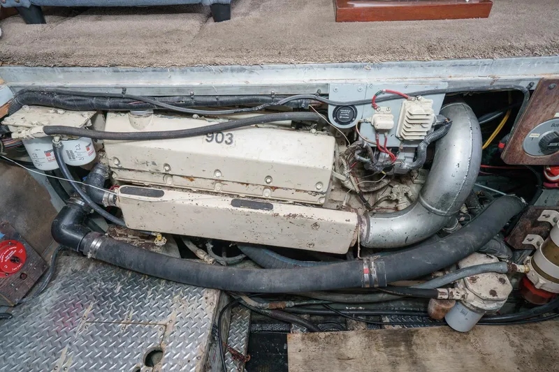 Slide: The Image of Engine compartment of a 1974 Hatteras Convertible Sportfisher, showcasing mechanical components and wiring. - 56
