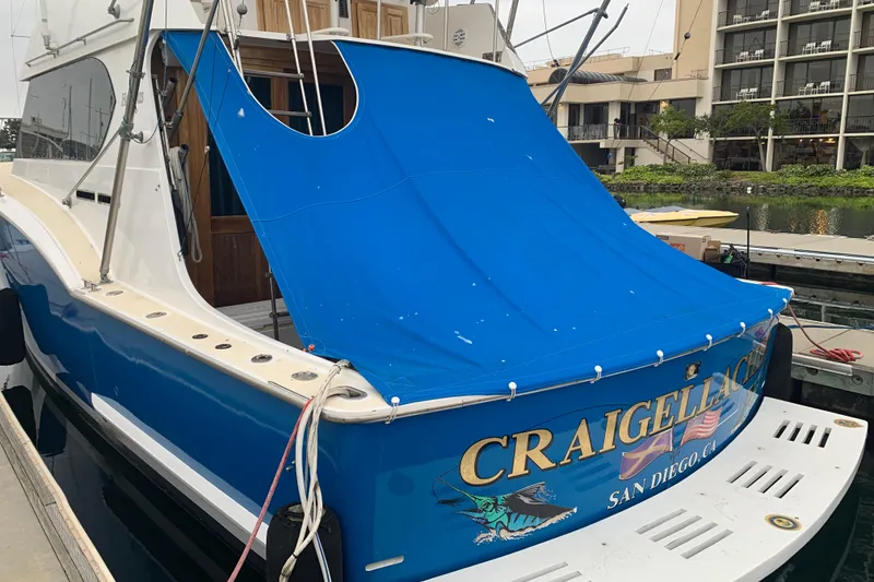 Slide: The Image of 1974 Hatteras Convertible Sportfisher boat docked, featuring blue cover and "CRAIGELLACHIE" name. - 64