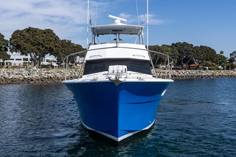 Slide: The Image of 1974 Hatteras Convertible Sportfisher boat on water, blue hull, coastal background. - 7