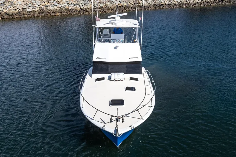 Slide: The Image of 1974 Hatteras Convertible Sportfisher boat on calm water, viewed from the front. - 8