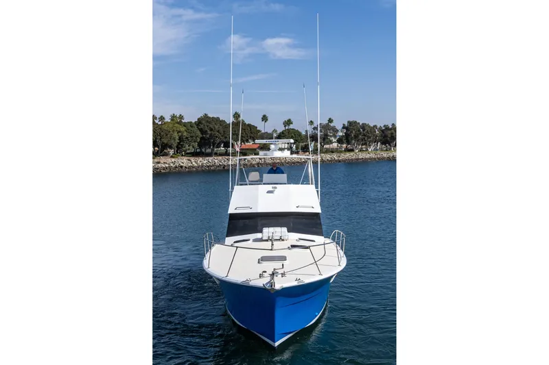 Slide: The Image of 1974 Hatteras Convertible Sportfisher boat on calm water, clear sky background. - 9