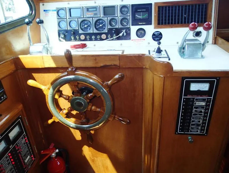 Slide: The Image of 1987 Tayana 45 Expedition Trawler helm with wooden wheel and control panel. - 12