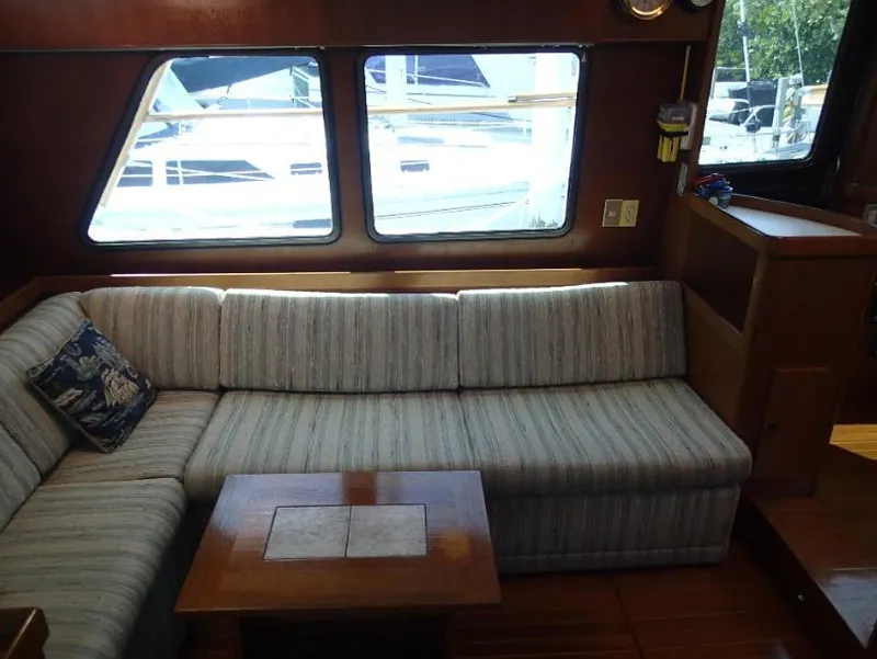 Slide: The Image of Interior of 1987 Tayana 45 Expedition Trawler with striped sofa and wooden table. - 13