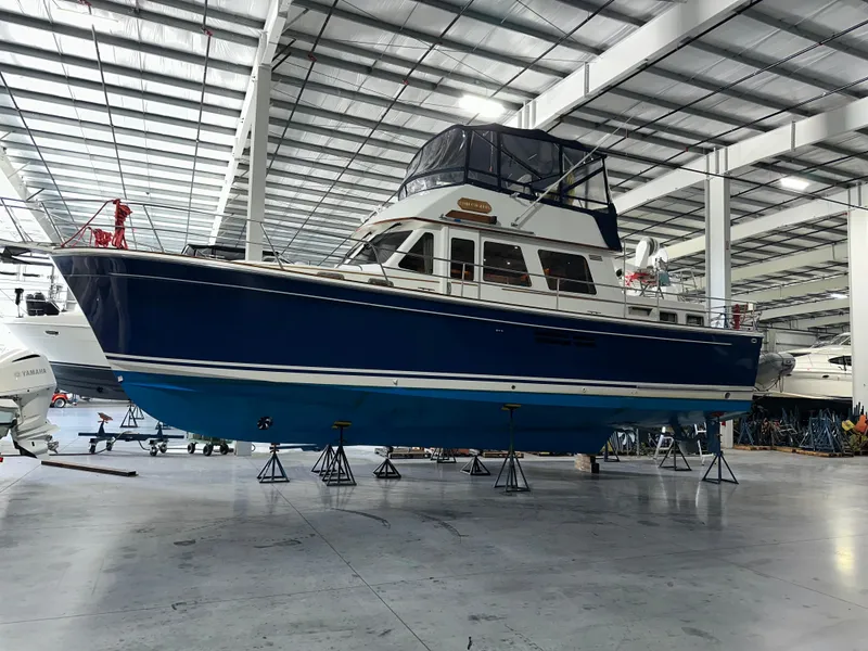 Slide: The Image of 2001 Sabreline 43 yacht in indoor storage, blue hull, elevated on stands. - 2