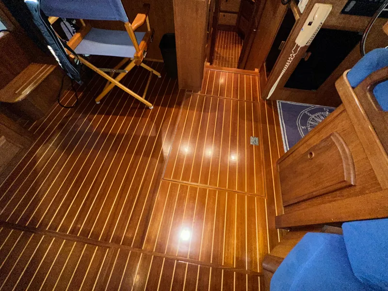 Slide: The Image of Polished wooden interior of 2001 Sabreline 43 yacht, featuring elegant flooring and seating. - 23