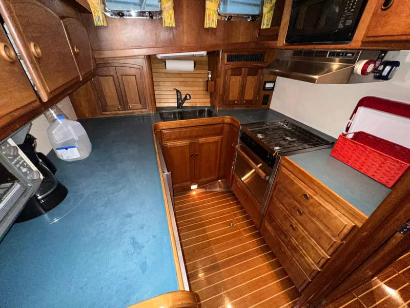 Slide: The Image of 2001 Sabre Sabreline 43 yacht kitchen with wooden cabinetry and modern appliances. - 25