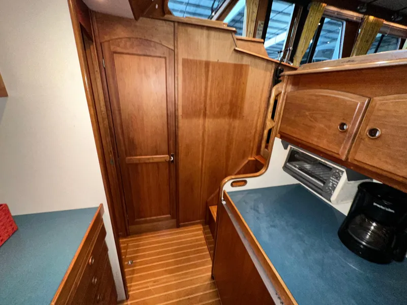Slide: The Image of Interior of 2001 Sabreline 43 yacht with wooden cabinetry and blue countertops. - 26