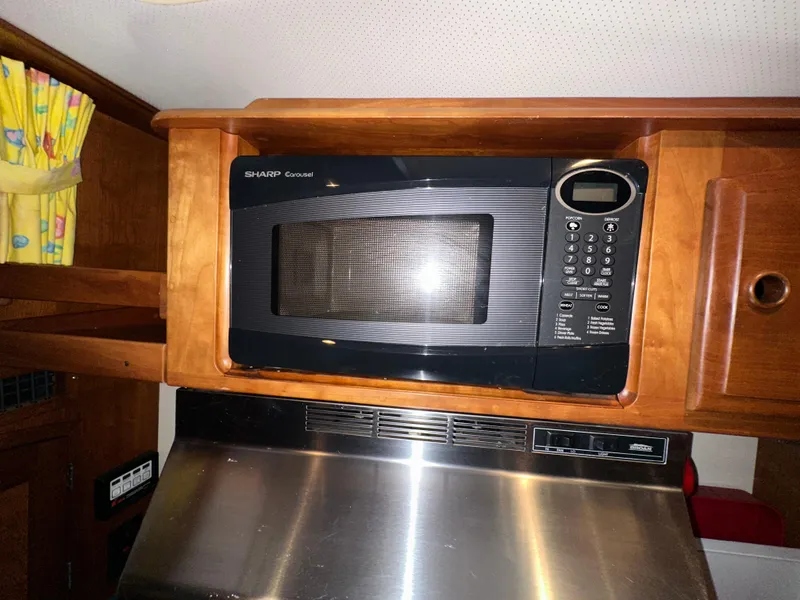 Slide: The Image of Microwave in 2001 Sabre Sabreline 43 yacht kitchen, wooden cabinetry, stainless steel accents. - 28