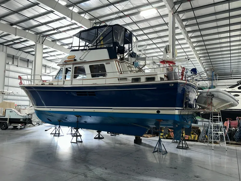Slide: The Image of 2001 Sabreline 43 yacht in a boatyard, elevated on stands, with a blue hull. - 3