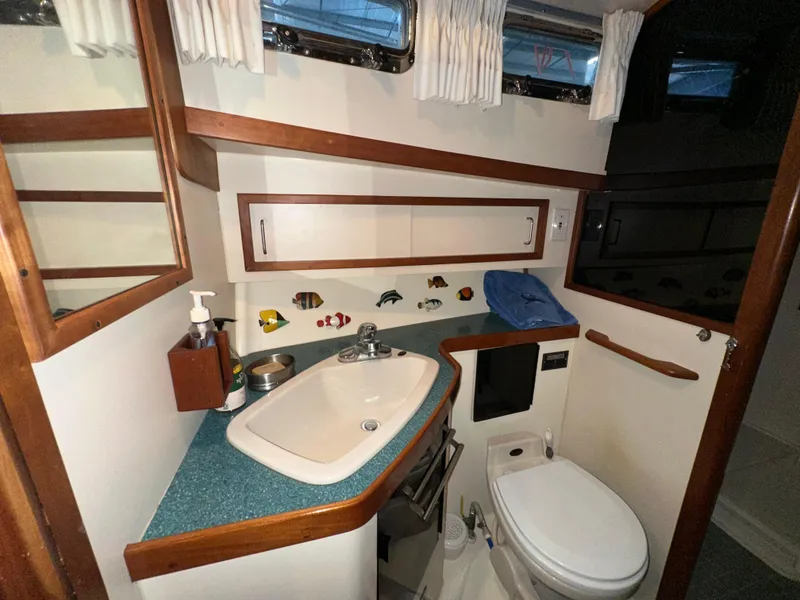 Slide: The Image of 2001 Sabre Sabreline 43 yacht bathroom with sink, toilet, and wooden accents. - 35